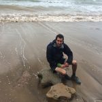 James sat on a dinosaur footprint at Hanover Point, Isle of Wight in 2017
