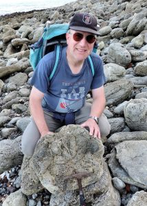 Steve Friedrich with a dinosaur footprint in Folkestone, Kent.